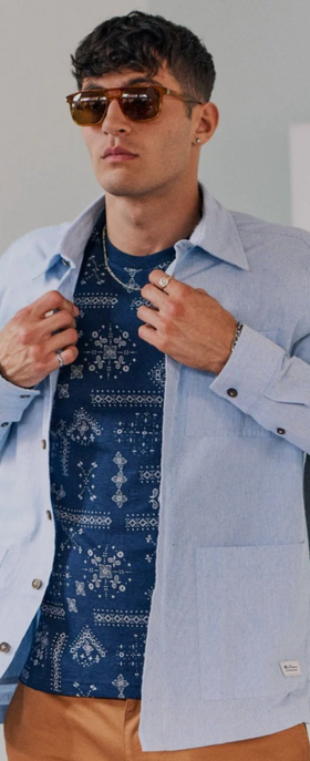 A man wearing a blue Ben Sherman button up shirt and blue t-shirt underneath