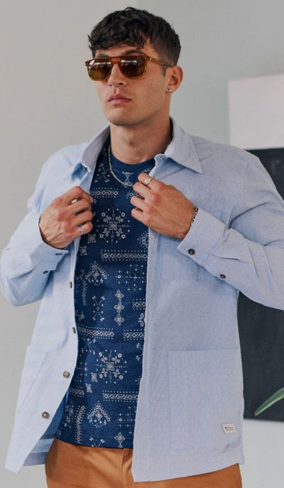 A man wearing a blue Ben Sherman button up shirt and blue t-shirt underneath