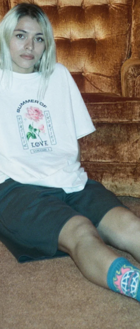 A woman wearing a 40s and Shorties white t-shirt and shorts