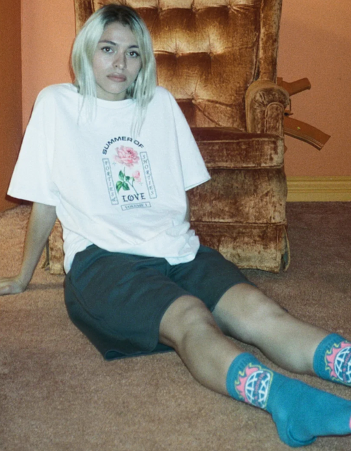 A woman wearing a 40s and Shorties white t-shirt and shorts