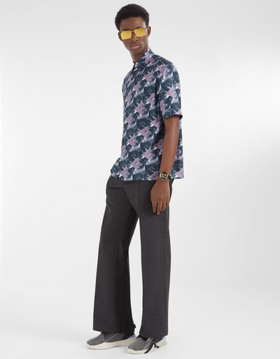 A man wearing a designer Fendi logo t-shirt and black bell-bottomed pants