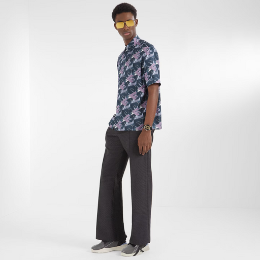 A man wearing a designer Fendi logo t-shirt and black bell-bottomed pants