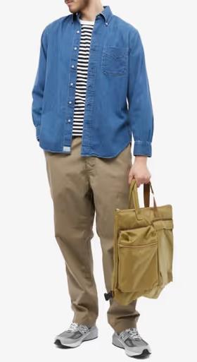 A man wearing orSlow denim shirt and khaki pants