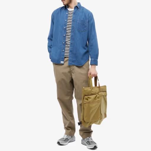 A man wearing orSlow denim shirt and khaki pants