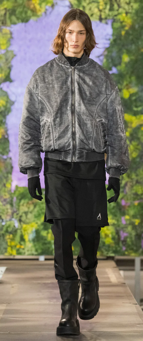 A man walking a runway wearing a 1017 ALYX 9SM outfit with a jacket and black pants