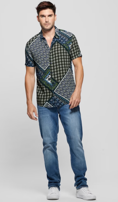 A man wearing a short-sleeve Guess button up and jeans