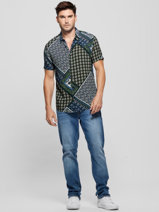 A man wearing a short-sleeve Guess button up and jeans