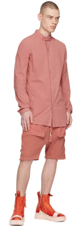 A man wearing a Boris Bidjan Saberi light red button up, shorts and bright red boots