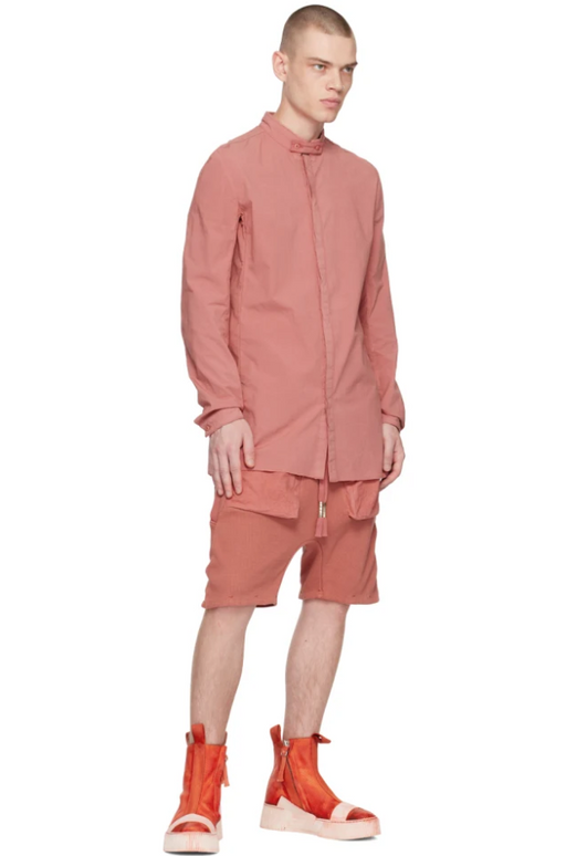 A man wearing a Boris Bidjan Saberi light red button up, shorts and bright red boots