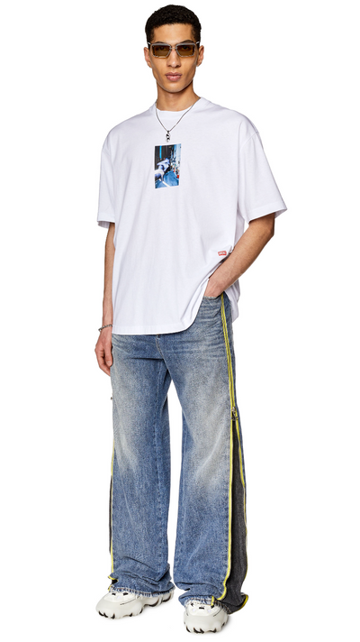 A man wearing a white Diesel t-shirt and jeans