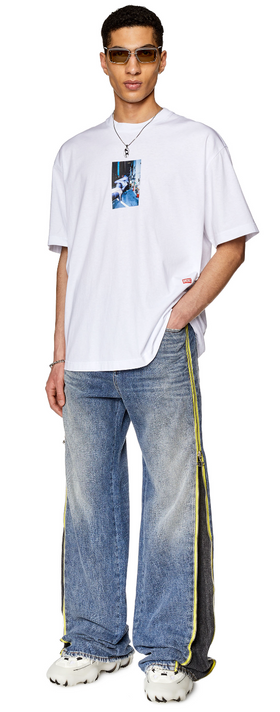 A man wearing a white Diesel t-shirt and jeans