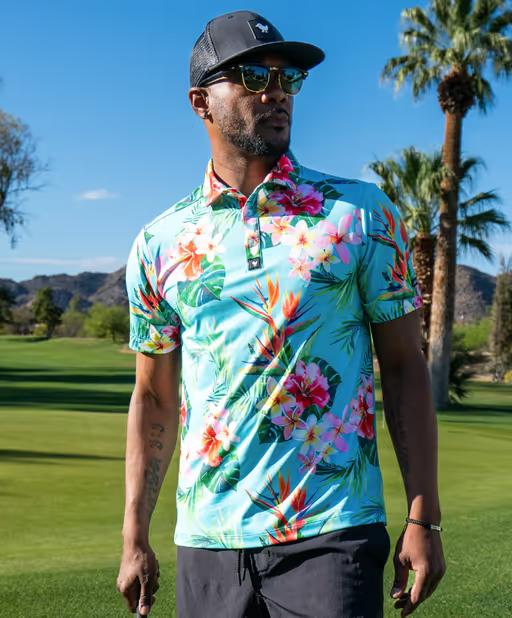 A man wearing a Bad Birdie floral golf shirt with a black hat