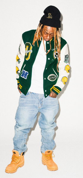Lil Wayne wearing an OVO varsity jacket, jeans and Timberlands