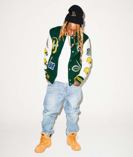 Lil Wayne wearing an OVO varsity jacket, jeans and Timberlands