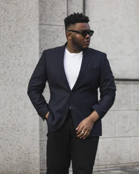 A man wearing a black Kenneth Cole suit with sunglasses