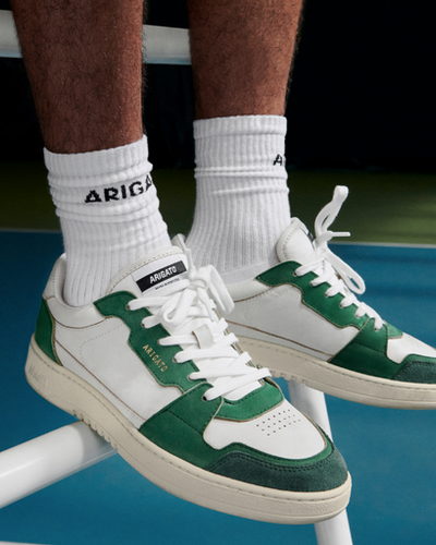A man wearing Axel Arigato green and white shoes and white branded socks