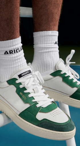 A man wearing Axel Arigato green and white shoes and white branded socks