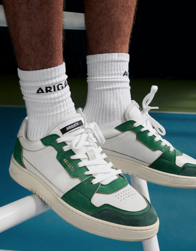 A man wearing Axel Arigato green and white shoes and white branded socks