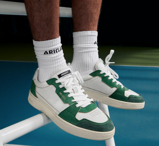 A man wearing Axel Arigato green and white shoes and white branded socks