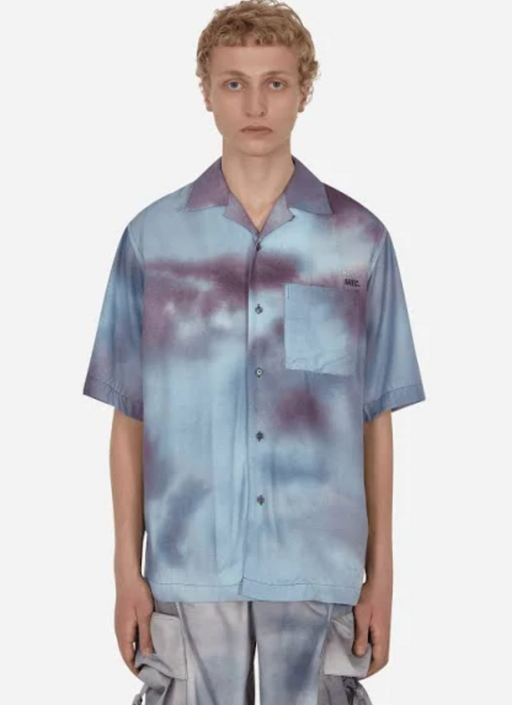 A man wearing a OAMC faded blue button up with matching cargo pants