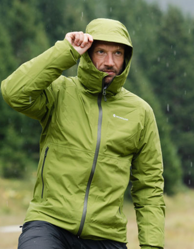 A man wearing a green Montane winter jacket with the hood on