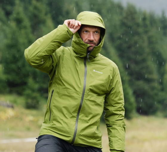 A man wearing a green Montane winter jacket with the hood on