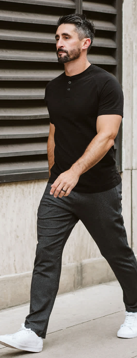A man wearing a Public Rec black t-shirt and pants with white shoes