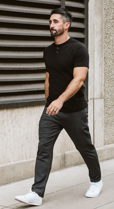 A man wearing a Public Rec black t-shirt and pants with white shoes
