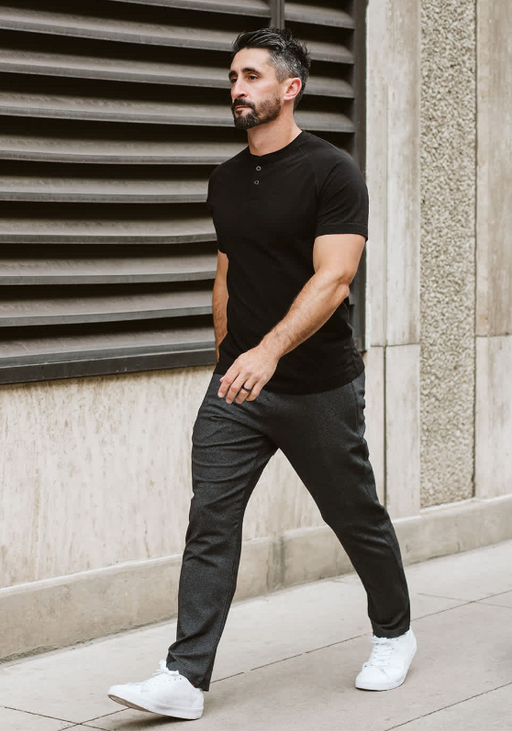 A man wearing a Public Rec black t-shirt and pants with white shoes