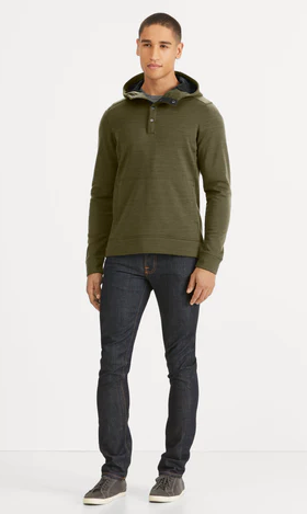 A man wearing a Nau olive green sweater and jeans