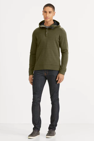A man wearing a Nau olive green sweater and jeans