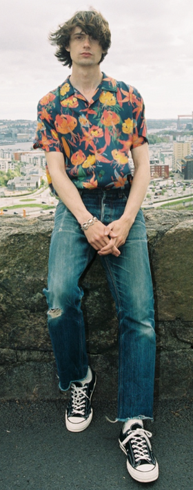 A man wearing a flora top with nudie jeans
