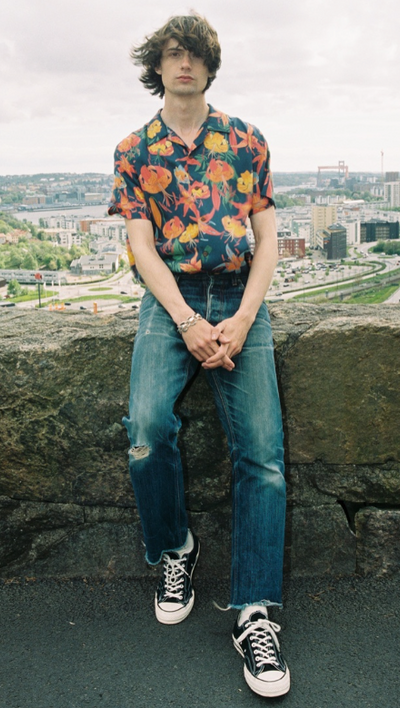 A man wearing a flora top with nudie jeans