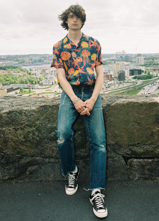 A man wearing a flora top with nudie jeans