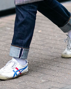 A man wearing a Onitsuka Tiger branded shoes and denim