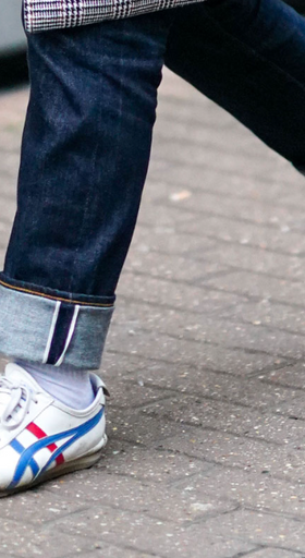 A man wearing a Onitsuka Tiger branded shoes and denim