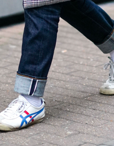 A man wearing a Onitsuka Tiger branded shoes and denim