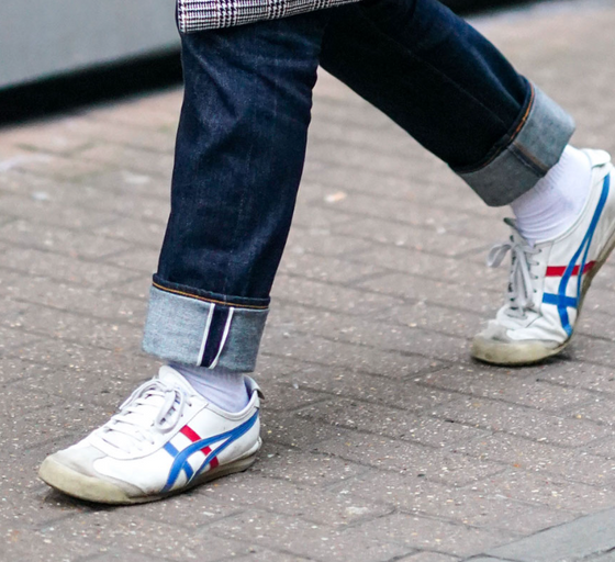 A man wearing a Onitsuka Tiger branded shoes and denim