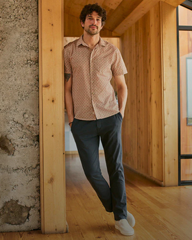 A man wearing a short-sleeve Marine Layer and navy blue pants