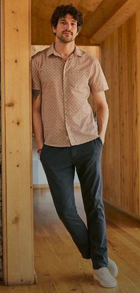 A man wearing a short-sleeve Marine Layer and navy blue pants
