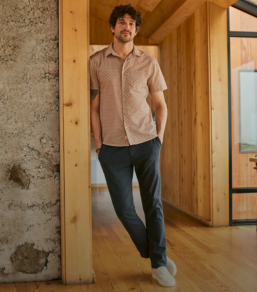 A man wearing a short-sleeve Marine Layer and navy blue pants