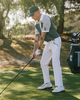 A man wearing a green Bogey Boys golf outfit in collaboration with Adidas