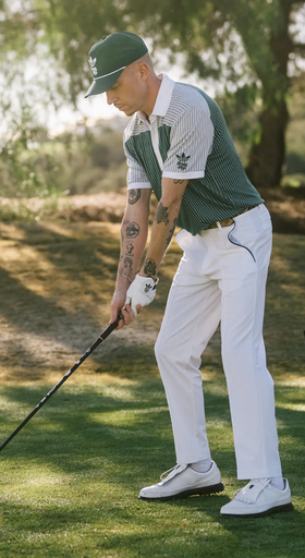 A man wearing a green Bogey Boys golf outfit in collaboration with Adidas