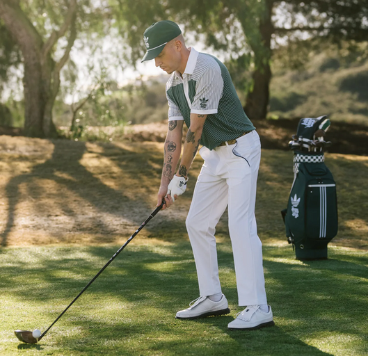 A man wearing a green Bogey Boys golf outfit in collaboration with Adidas