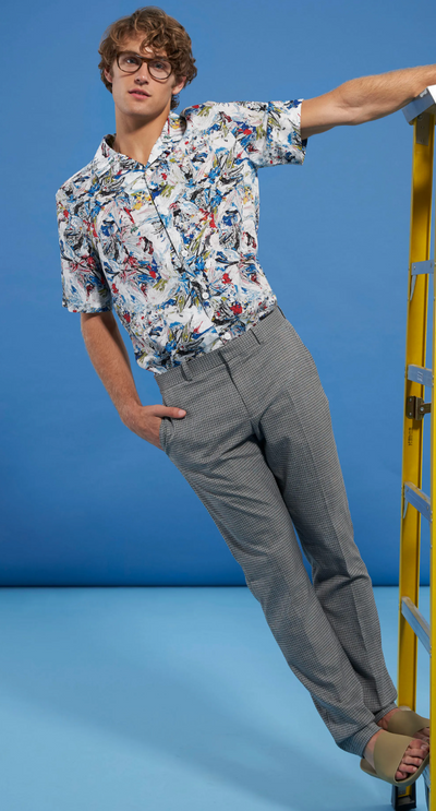 A man wearing a floral Perry Ellis button up and grey slacks