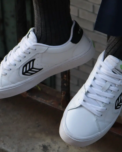 A man wearing a Cariuma white casual shoes