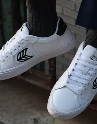A man wearing a Cariuma white casual shoes