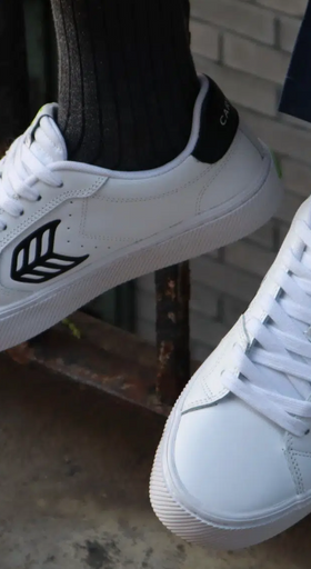 A man wearing a Cariuma white casual shoes