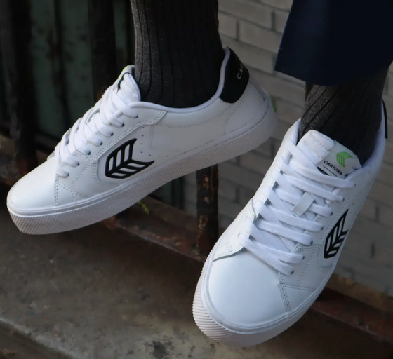A man wearing a Cariuma white casual shoes