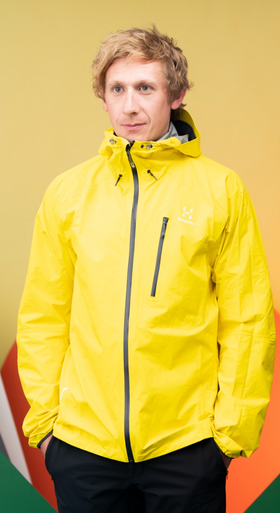 A man wearing a bright yellow Haglöfs jacket and black pants